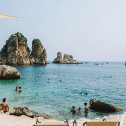 pexels-photo-17467015-17467015 Relaxing beach scene in Scopello, Sicily with crystal clear water and lounging chairs.