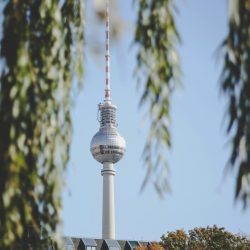 pexels-photo-624363-624363 Berlin's iconic TV Tower framed by autumn leaves, captured on a clear day.